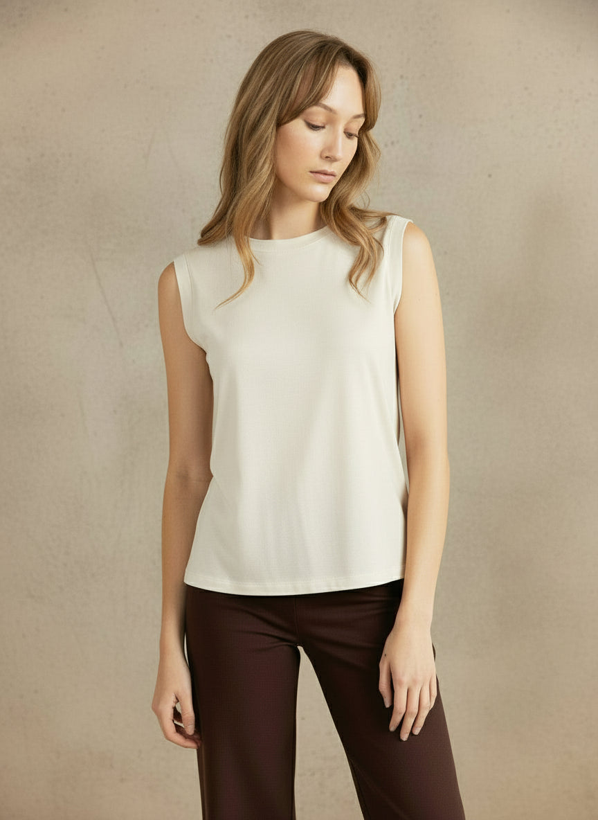Woman wearing a brown sleeveless top and pants against a beige background