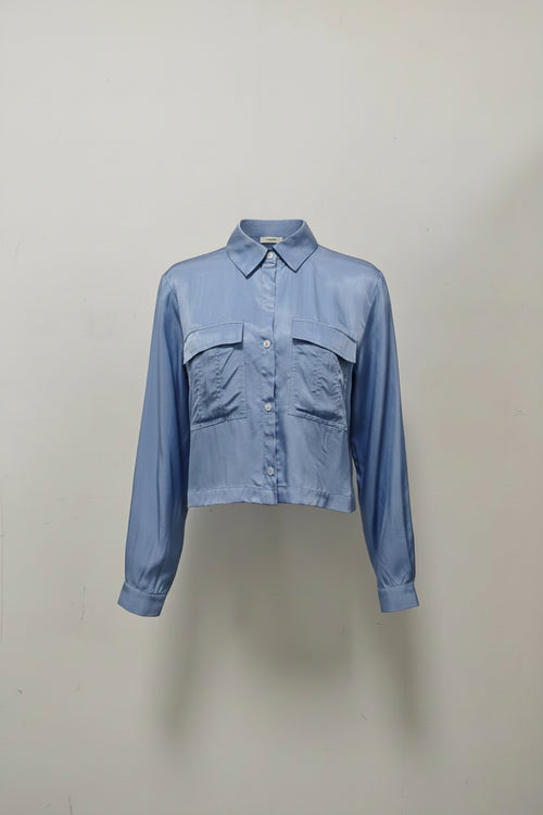 Blue double pocked womens shirt against a plain background